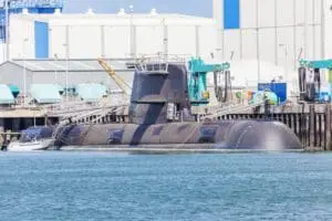 Submarine in partially submerged in water at a naval shipyard