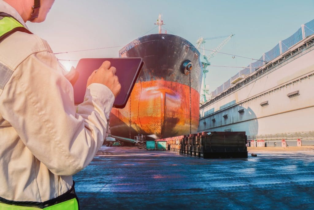 Surveyor inspecting ship in floating dock