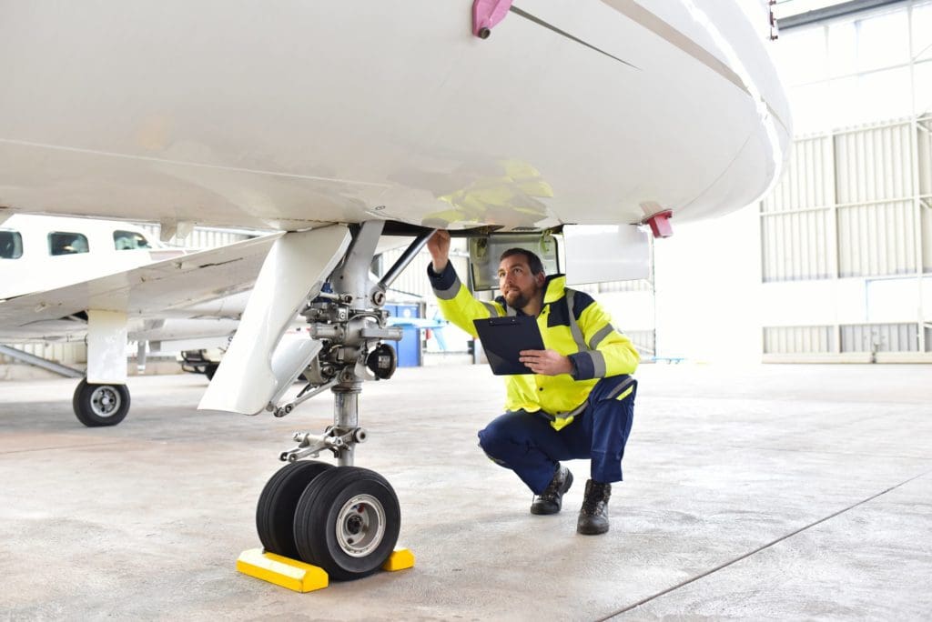 Mechanic assesses needed repairs to a plane.