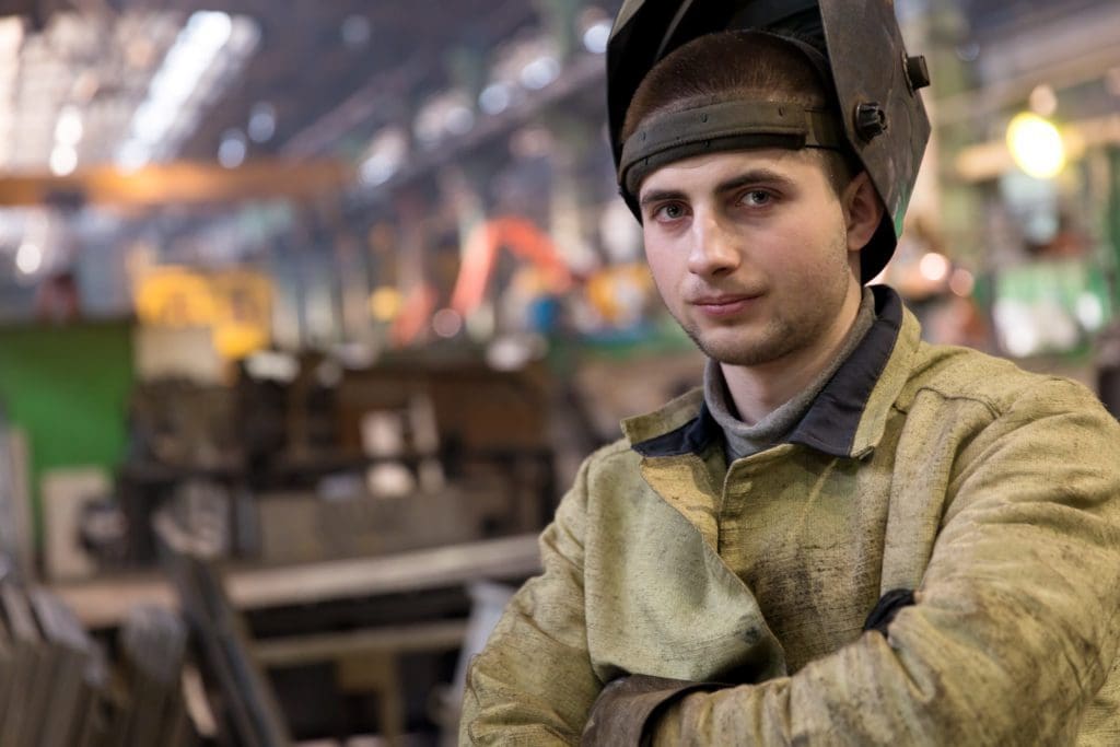 man in welding jacket with welding mask on head