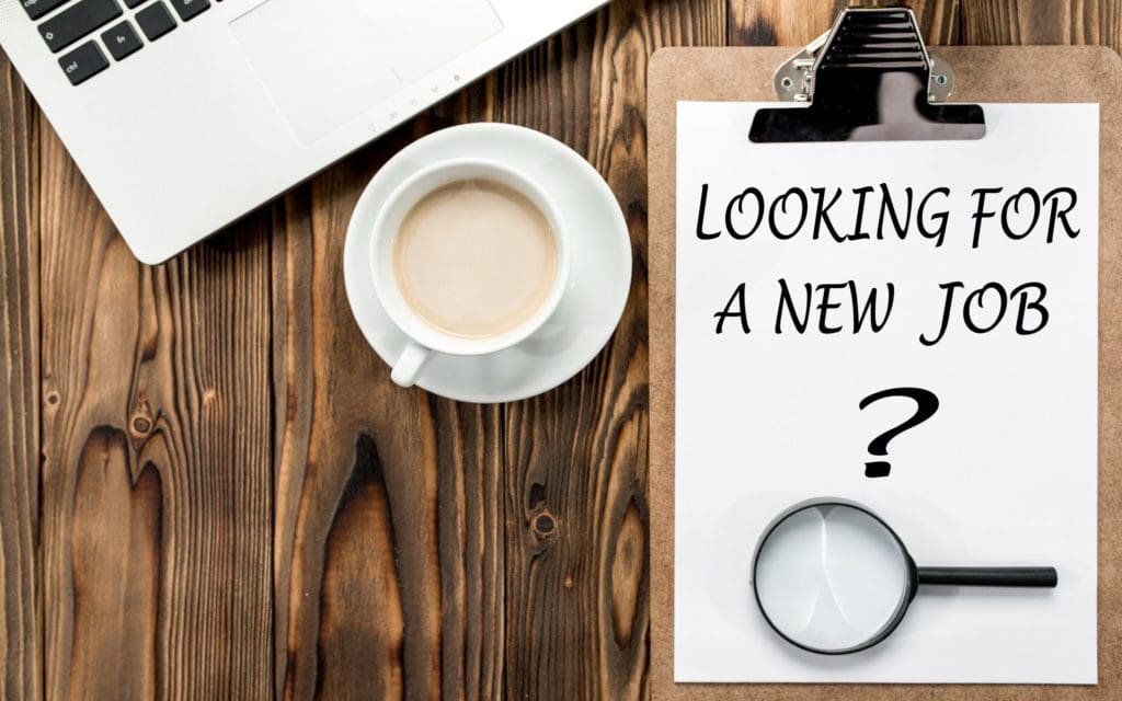 Image with coffee cup, computer and clipboard with "Looking for a New Job?" on a piece of paper