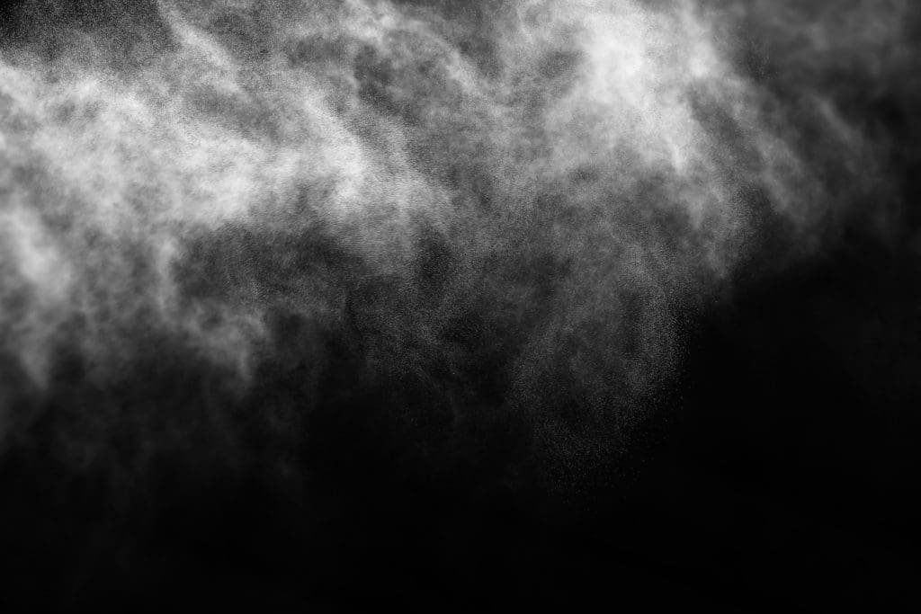 Cold spray particles on a black background.