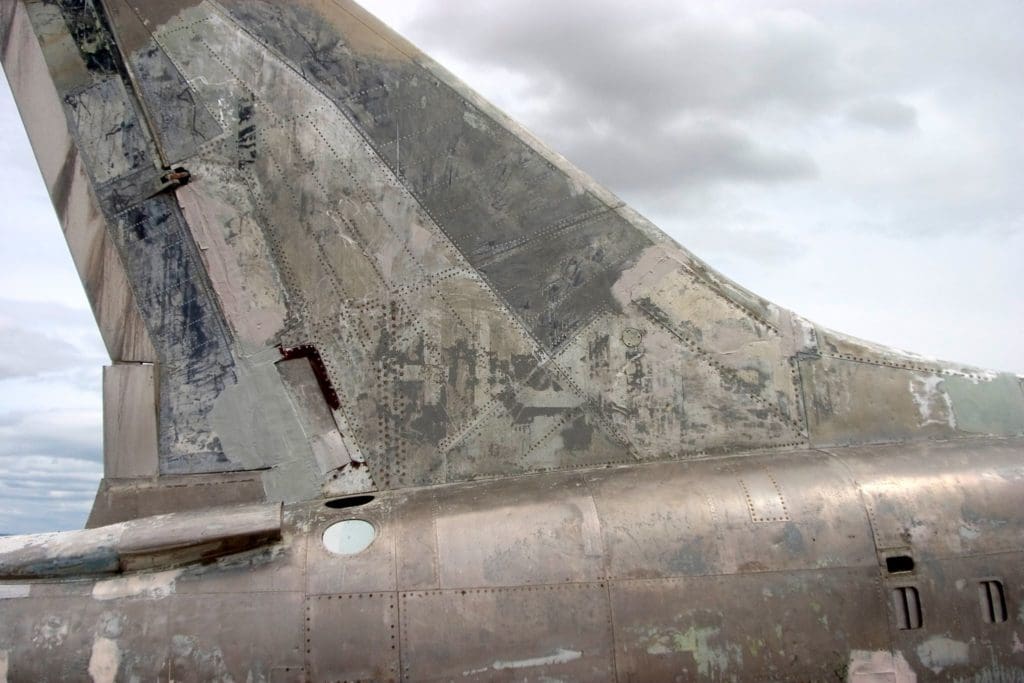 weathered tail section of a jet in need of aircraft sheet metal construction and repair