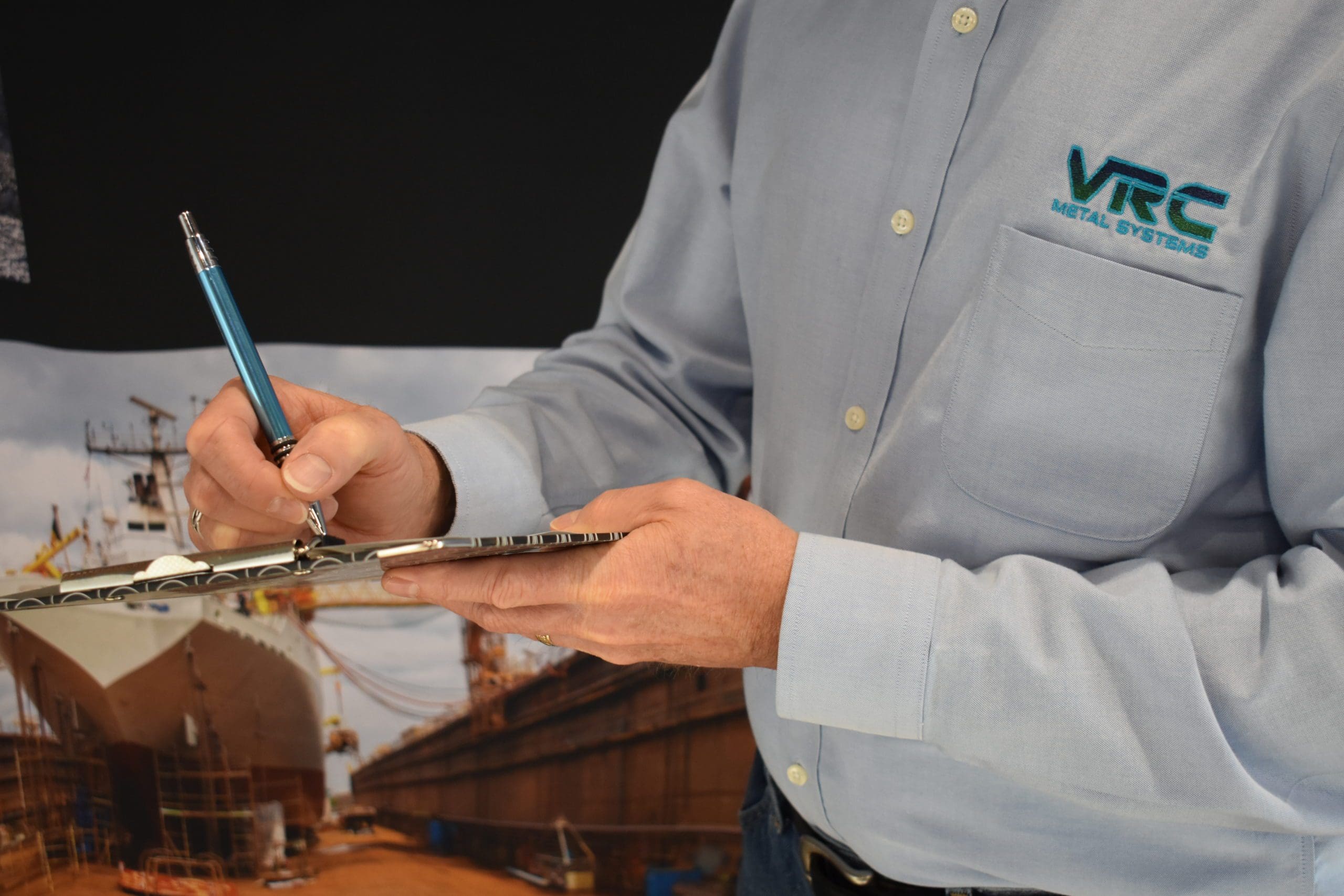 A VRC Metal Systems employee writing a quote.