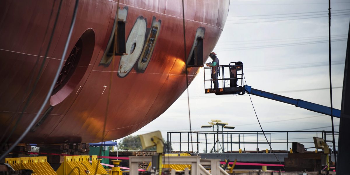 Worker Repairing Container Ship At Industry