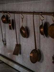 copper pots and pans on rack with antimicrobial surface visible