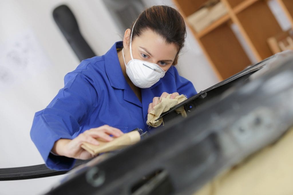 woman worker wearing mask as she preps for surface coating